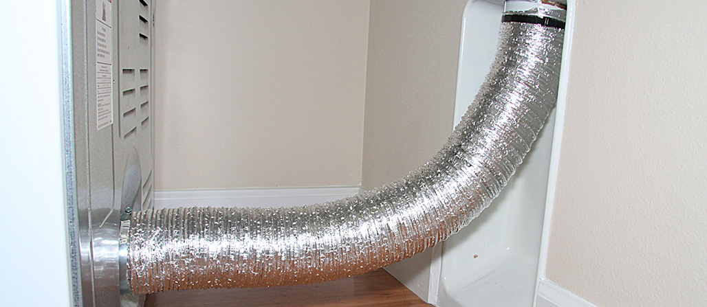 A flexible dryer vent hose behind dryer connection